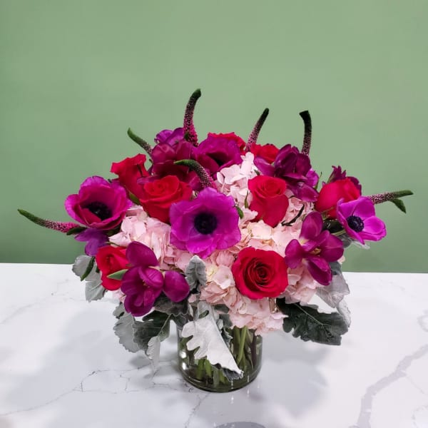 Pink and purple flower arrangement in a glass vase