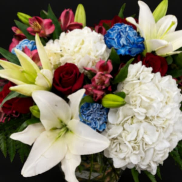 Mixed bouquet with white lilies, hydrangeas, roses, and bright accent flowers