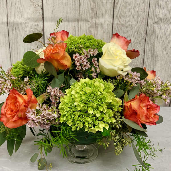 Mixed bouquet of roses and green hydrangeas in a glass vase