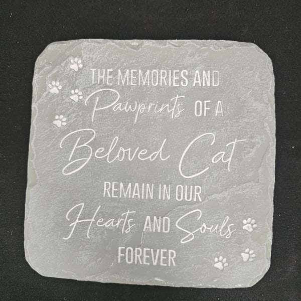 Gray memorial plaque with paw prints and a cat remembrance message