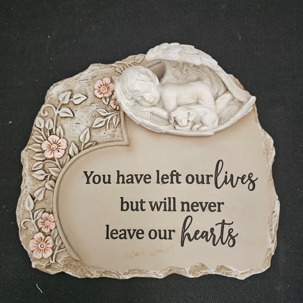 Decorative memorial plaque with a sleeping child and dog relief