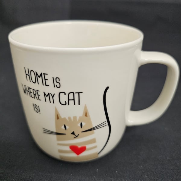 White mug with a cat illustration and the words "Home is where my cat is"
