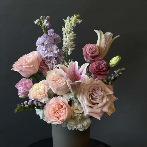 Pastel bouquet of roses, lilies, and mixed blooms in a vase