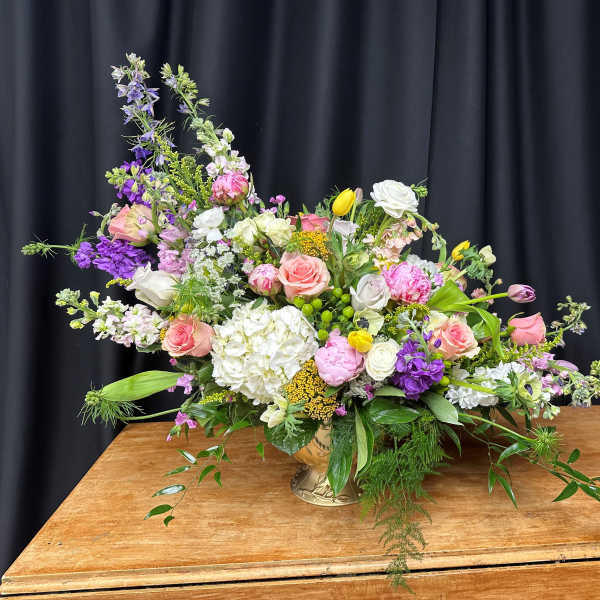Large mixed bouquet in a gold vase with pink, white, and purple flowers