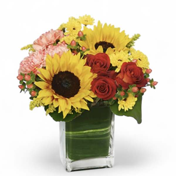 Bouquet of sunflowers, red roses, and pink carnations in a glass vase