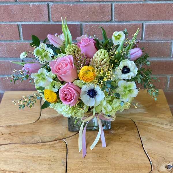 Pink and white mixed bouquet in a glass vase with ribbon