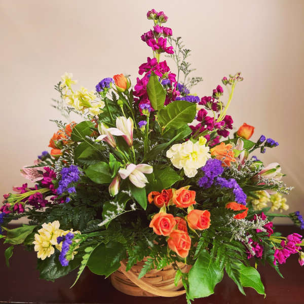 Colorful mixed flower arrangement in a woven basket