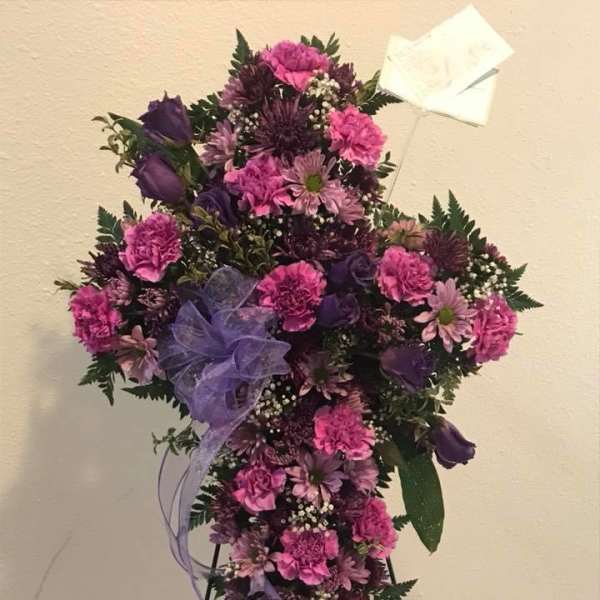 Purple and pink standing floral spray on an easel with a ribbon bow