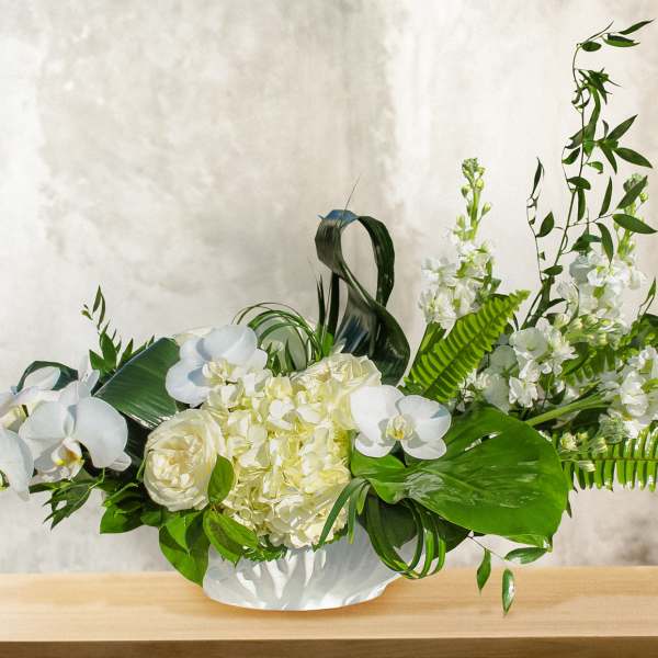 White orchid and hydrangea arrangement in a low white vase