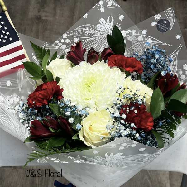 Bouquet of white roses, red carnations, and dark red flowers in clear wrap