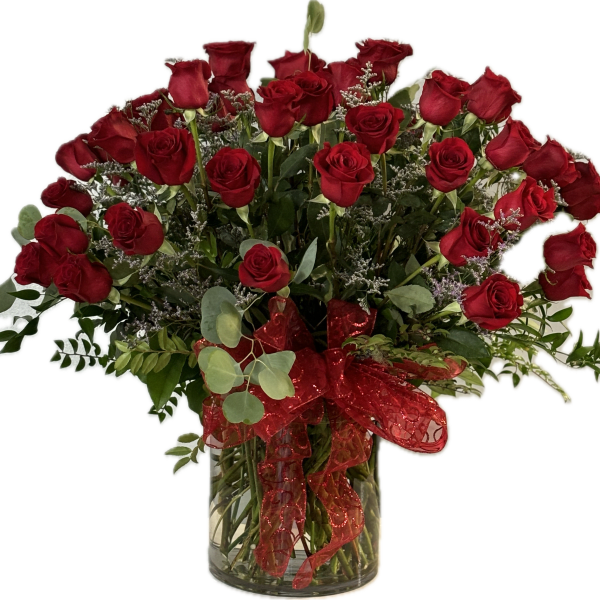 Bouquet of red roses in a clear glass vase with a red ribbon