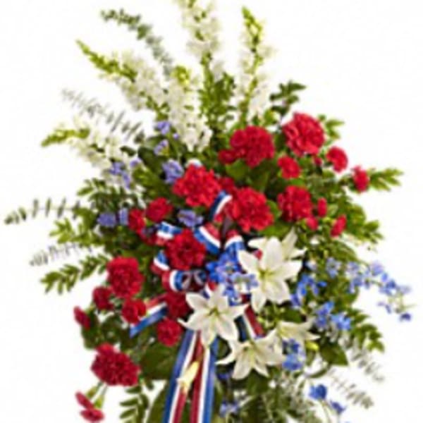 Standing floral spray with red, white, and blue flowers on an easel