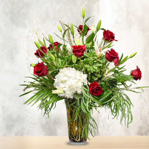 Red roses and white hydrangea in a glass vase