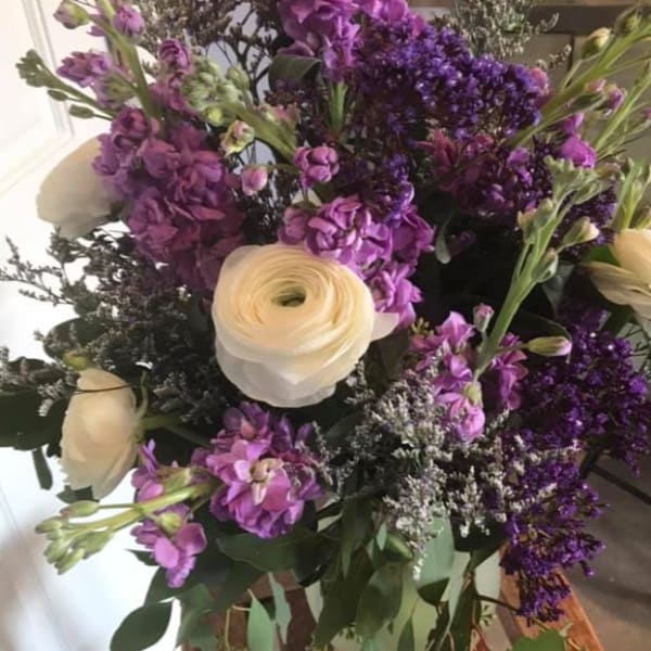 Purple and white mixed flower bouquet with a cream ranunculus
