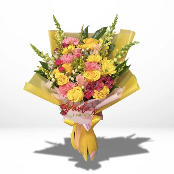 Bouquet of yellow and pink flowers wrapped in yellow paper
