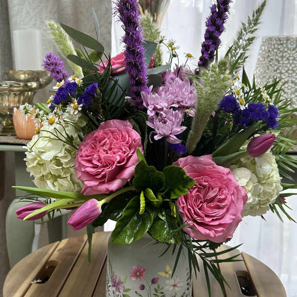 Pink and purple mixed flower arrangement in a floral ceramic vase