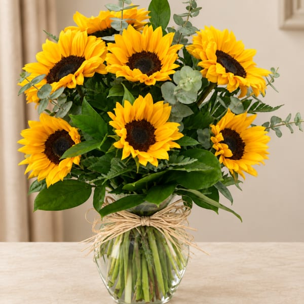 Bouquet of yellow sunflowers in a clear glass vase