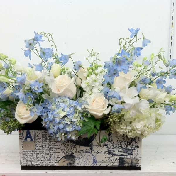 Blue and white floral arrangement in a decorative rectangular box