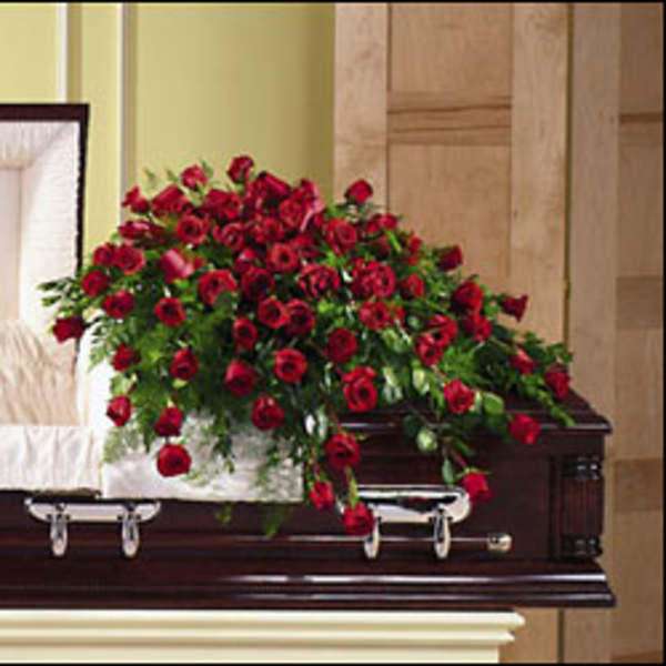 Red rose casket spray on a dark wood casket