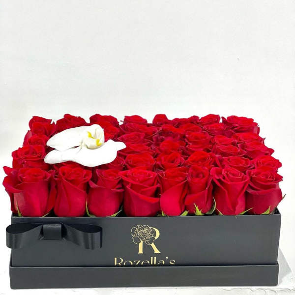 Box of red roses with a white orchid accent