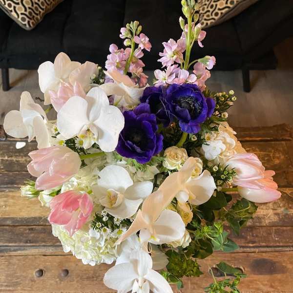Bouquet of white orchids, pink tulips, and purple anemones