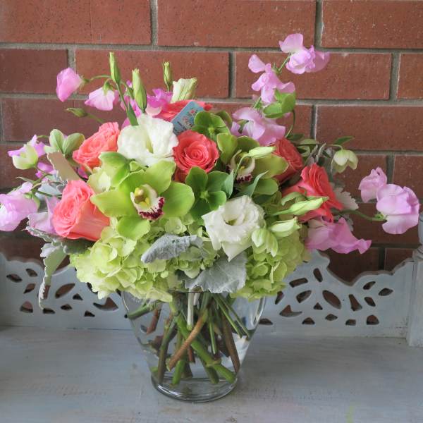 Pink and white floral arrangement in a clear glass vase