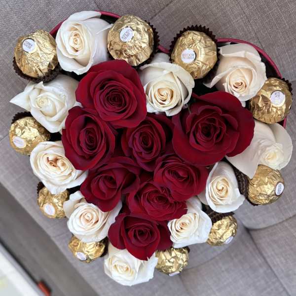 Heart-shaped bouquet of red and white roses with gold-wrapped chocolates
