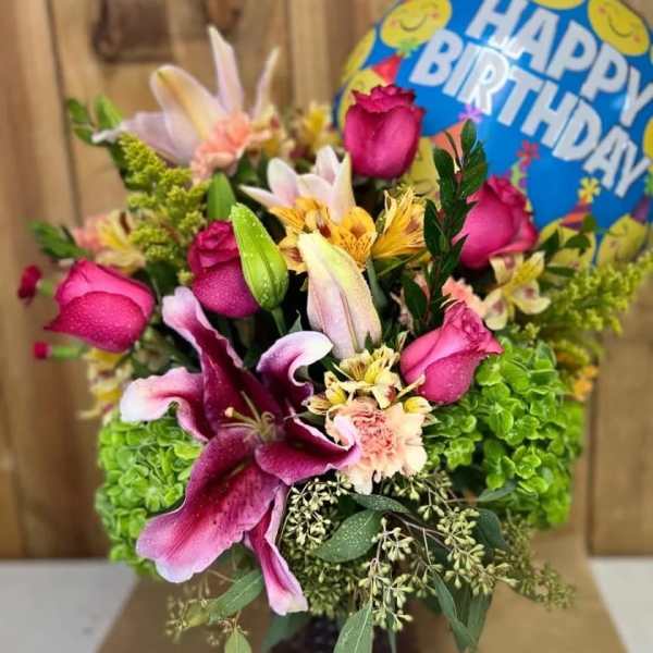 Bouquet of pink roses and lilies with a birthday balloon