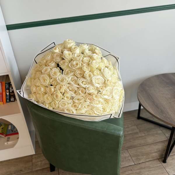 Large bouquet of cream roses wrapped in white paper