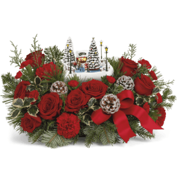 Red roses arranged with a small winter village centerpiece