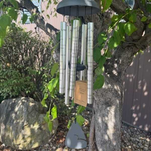 Wind chime hanging from a tree branch outdoors