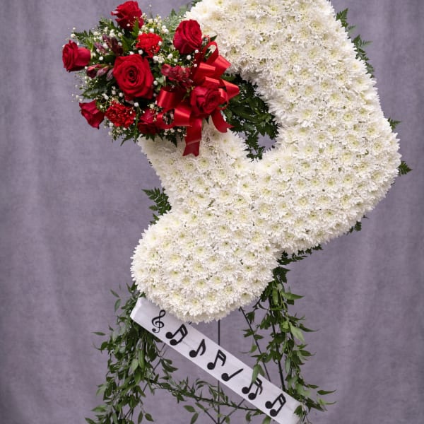Standing floral wreath with white chrysanthemums and red roses on an easel