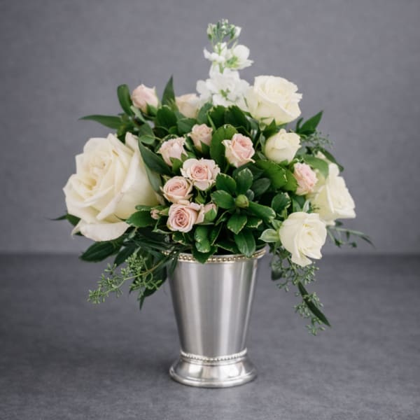 White and blush roses arranged in a silver vase