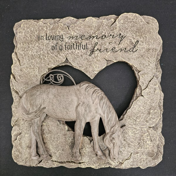 Stone memorial plaque with a horse relief and heart cutout