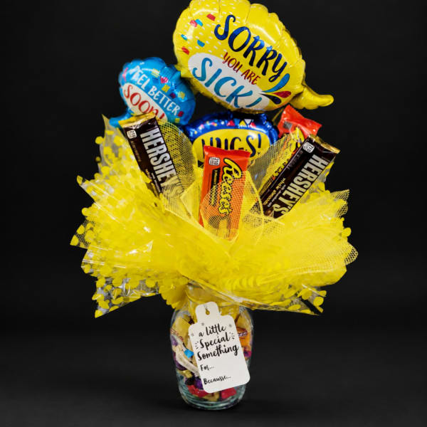 Candy bouquet in a glass jar with yellow balloons and chocolate bars