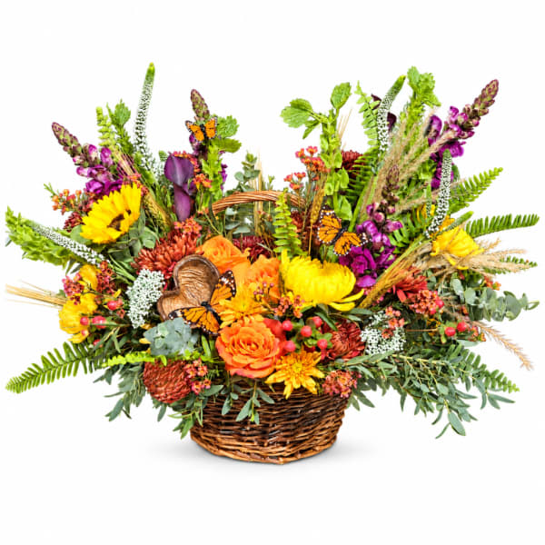 Basket arrangement with orange, yellow, and purple flowers and butterfly accents