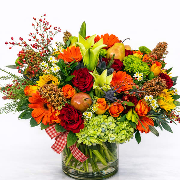 Bright mixed bouquet with roses, lilies, and gerbera daisies in a glass vase