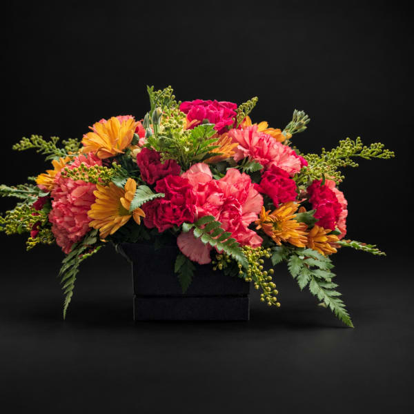 Colorful bouquet of carnations and daisies in a black box