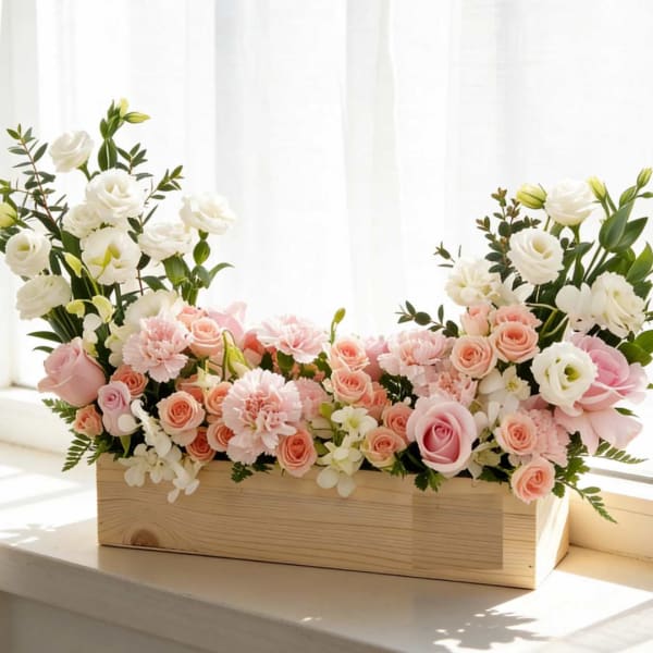 Pink and white floral arrangement in a wooden box