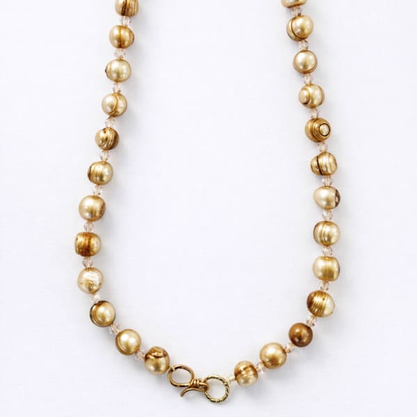 Gold beaded necklace on a white background