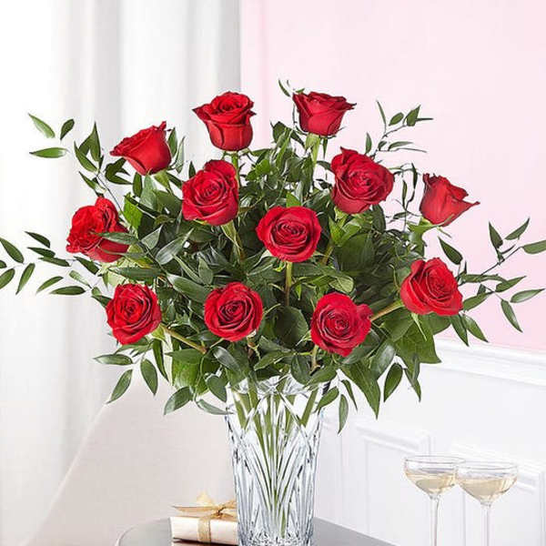 Red roses arranged in a clear glass vase