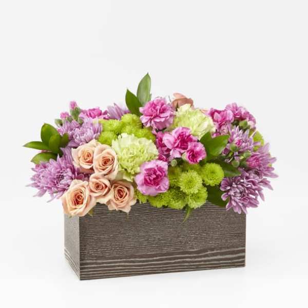 Pink and green flower arrangement in a rectangular wooden box