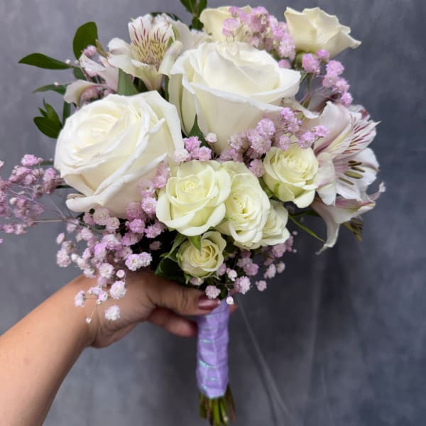 Handheld bouquet of white roses and pink filler flowers