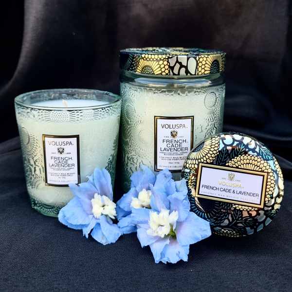 Three lavender-scented candles with blue flowers in front