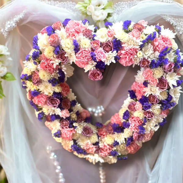 Heart-shaped floral wreath with pink, white, and purple flowers