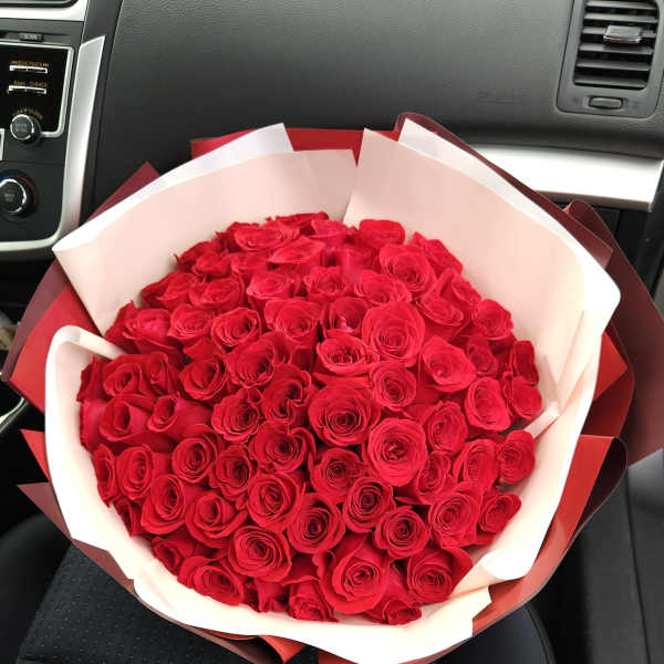 Large bouquet of red roses wrapped in white and red paper