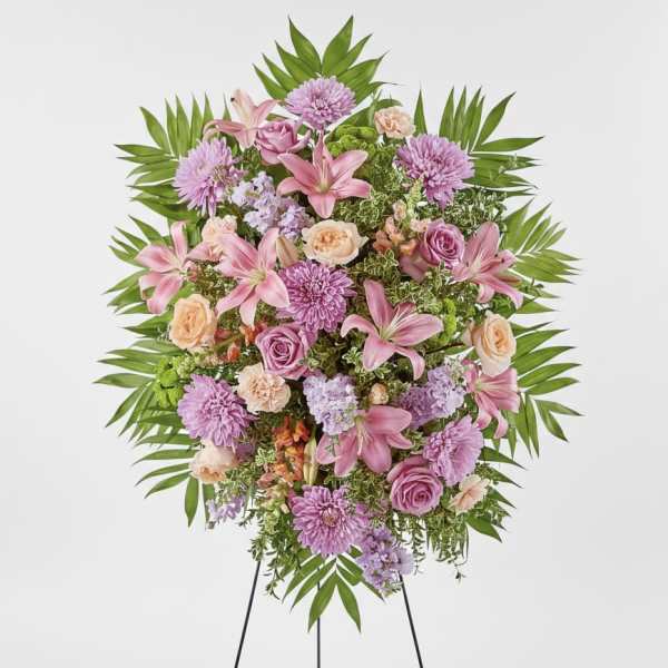 Standing floral spray with pink lilies, roses, and purple blooms