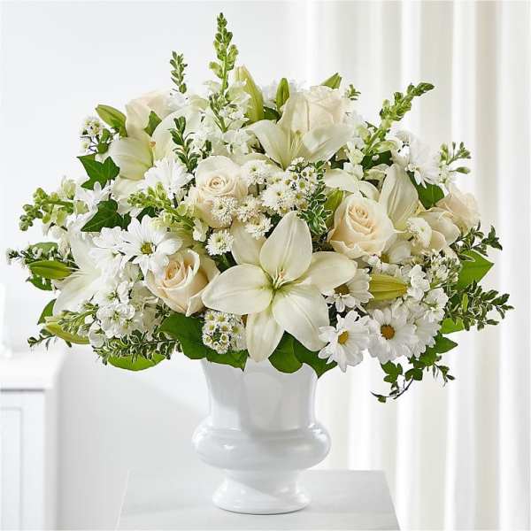 White floral arrangement in a white pedestal vase