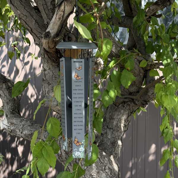 Butterfly-themed wind chime hanging from a tree branch