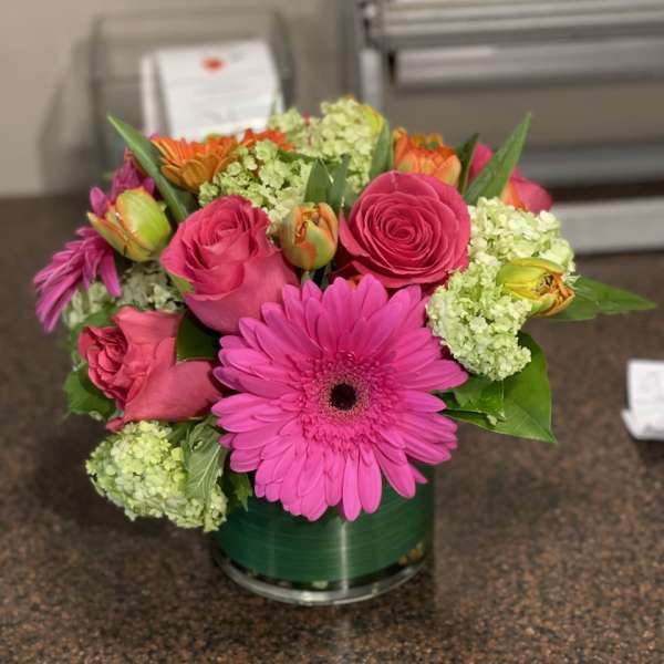 Pink and orange mixed bouquet in a glass vase